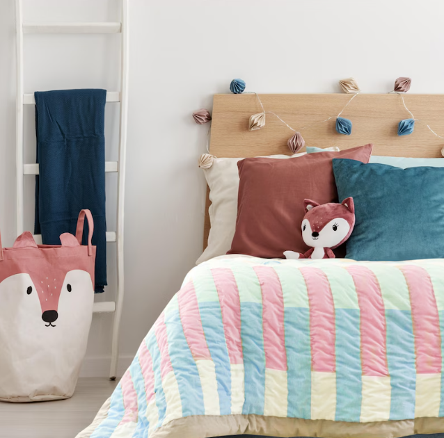 Handmade cotton quilt with modern geometric stripes styled on a bed; soft and breathable kids blanket ideal for crib, toddler, or twin bedding in a cozy nursery.