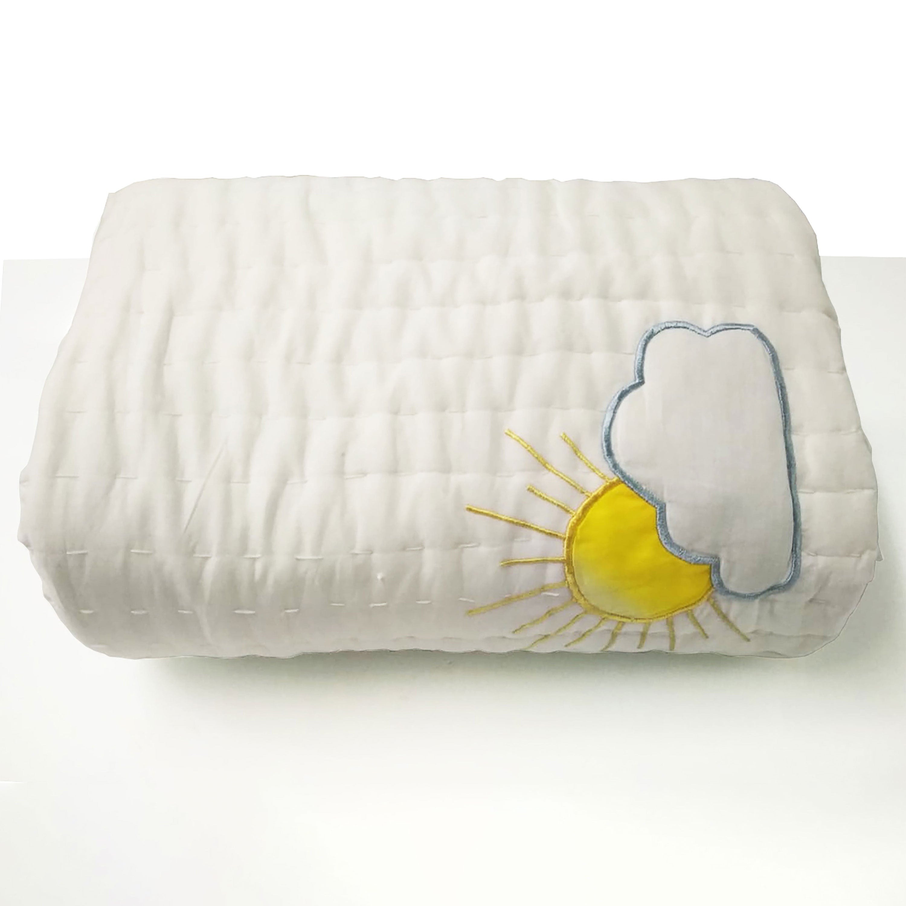 Close-up of rainbow and cloud embroidery on handcrafted cotton quilt, featuring detailed stitching and breathable soft fabric. Ideal for nursery bedding or baby shower gifts.