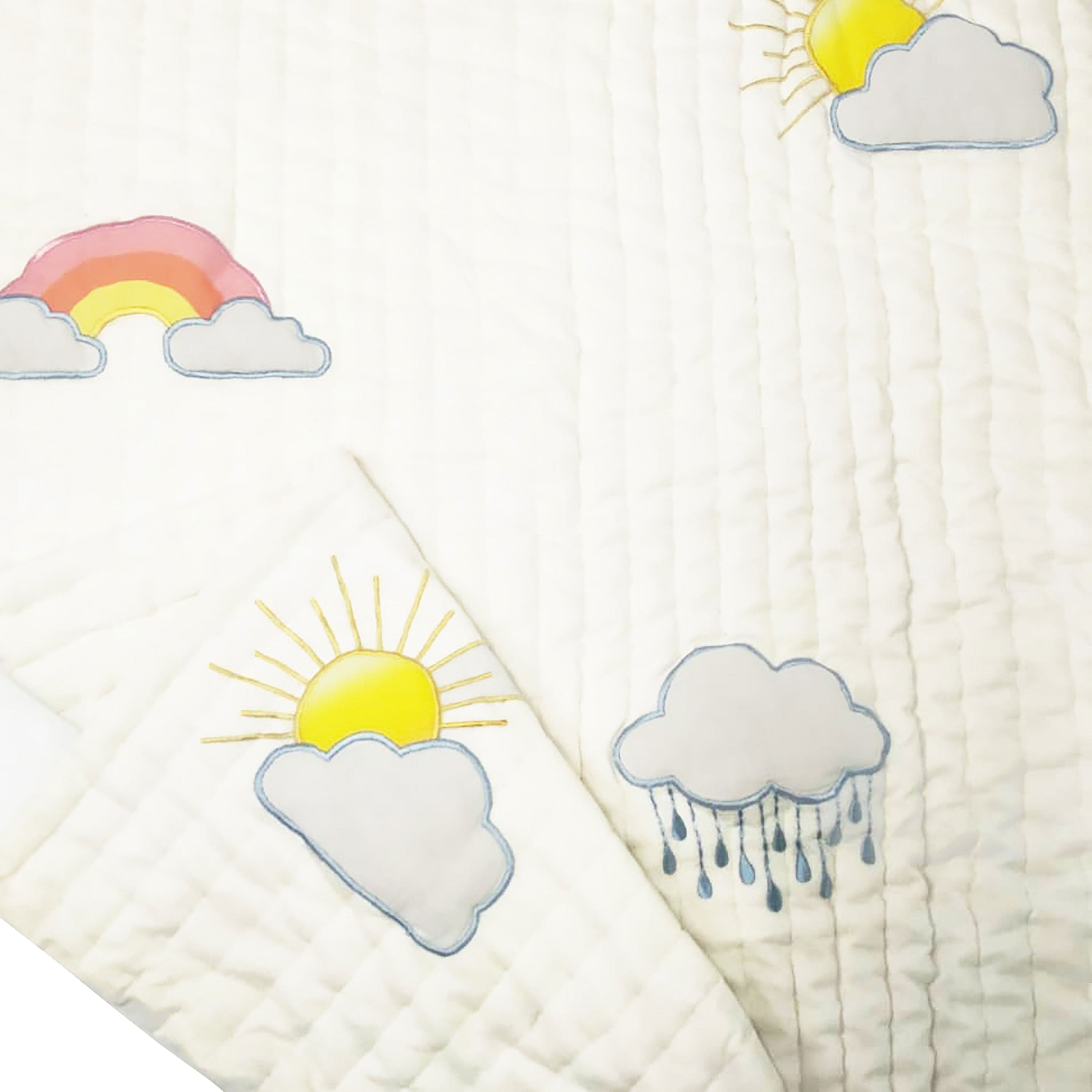 Folded handmade cotton quilt with rainbow and cloud embroidery, showcasing soft, lightweight layers—perfect for cozy nursery décor or thoughtful baby shower gifts.