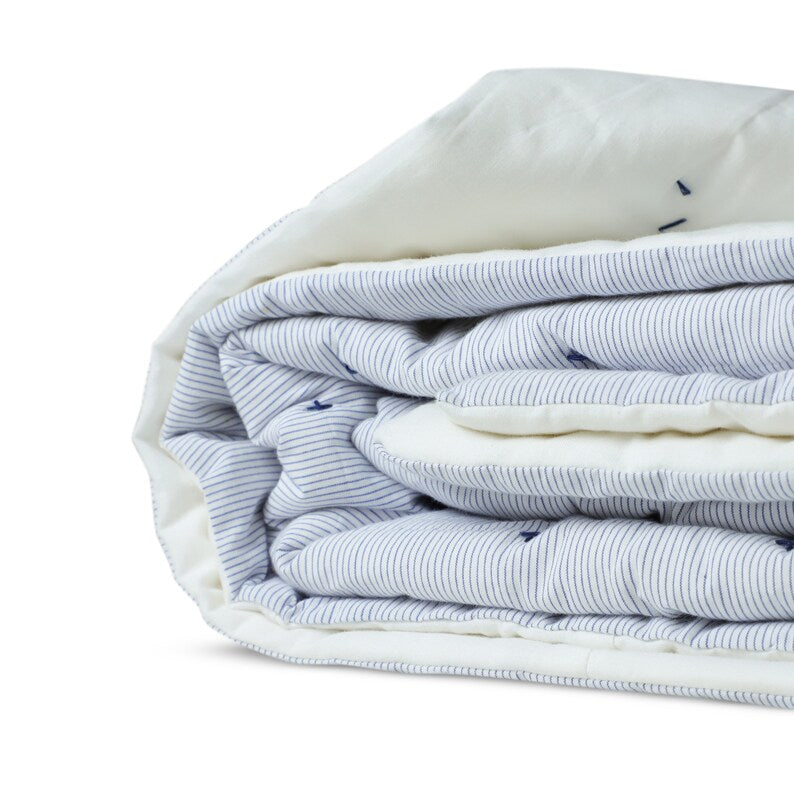 Machine washable on a gentle cycle, this cotton quilt offers cozy duvet-like comfort with a lighter fill, perfect for layering. Its flawless finish and secure construction make it easy to care for.