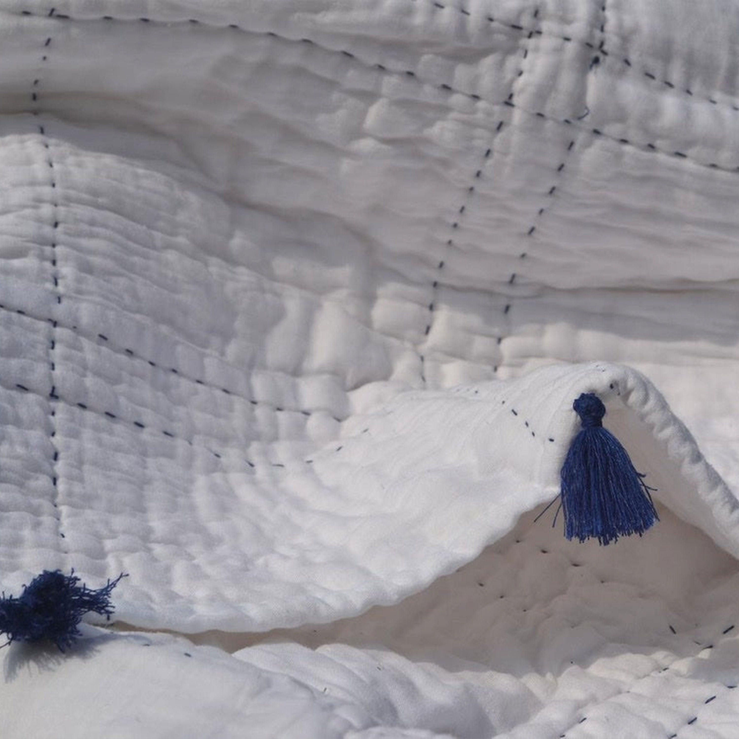 "Pick-stitched quilt features white or ivory cotton on top, reversing to plain cotton voile with soft cotton batting. Machine washable on a gentle cycle for easy care."