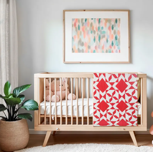 Handcrafted modern red patchwork baby quilt with diamond design, soft lightweight blanket.