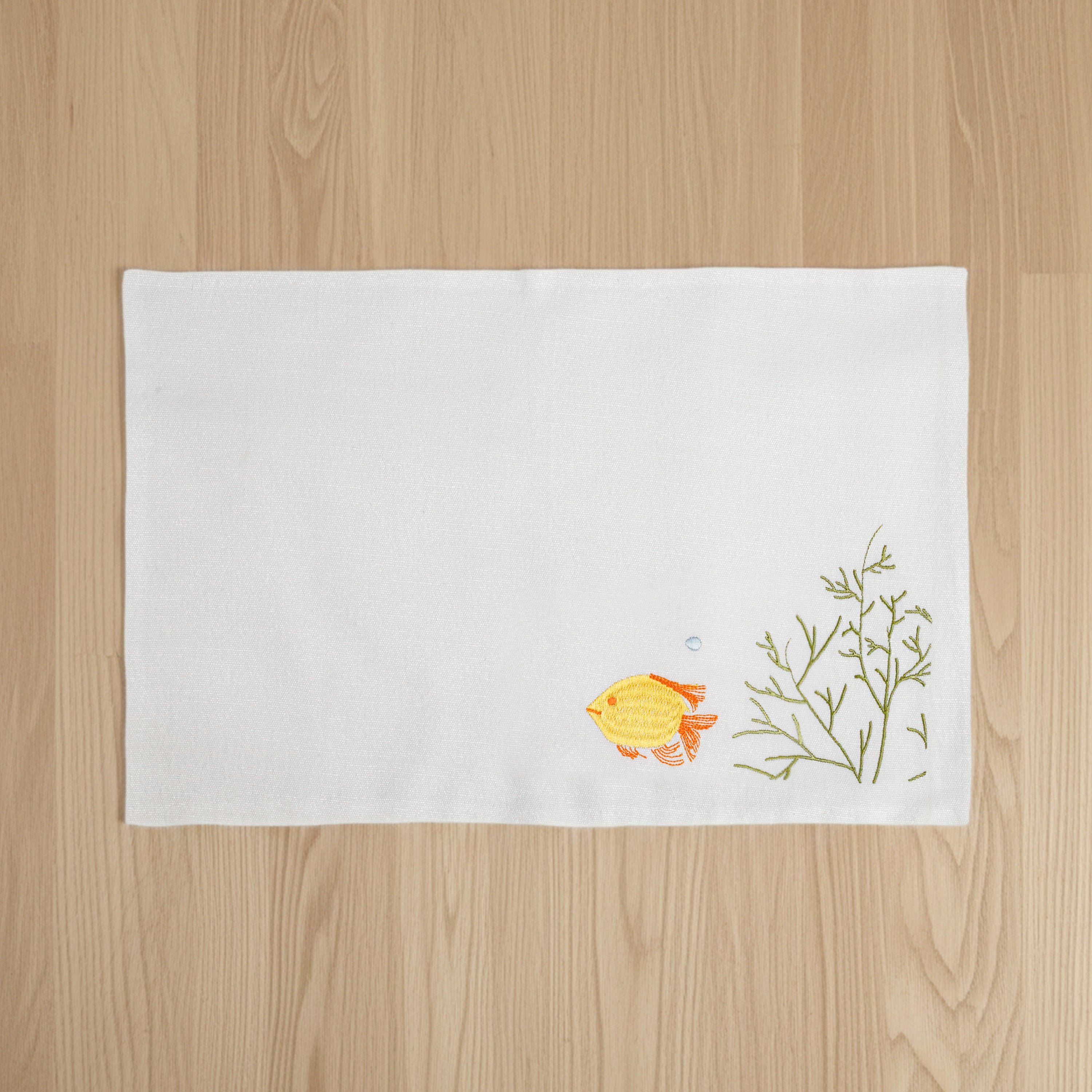 Best nautical cotton placemats set of 6 for beach house kitchen décor. This ivory cotton blend placemat features a detailed yellow tropical fish embroidery and green sea coral design. At 12x18 inches, it provides the perfect answer for how to create a polished coastal tablescape. The medium-weight, high-quality fabric ensures durability for summer gatherings and everyday dining, offering a unique farmhouse nautical aesthetic that protects your table with style.
