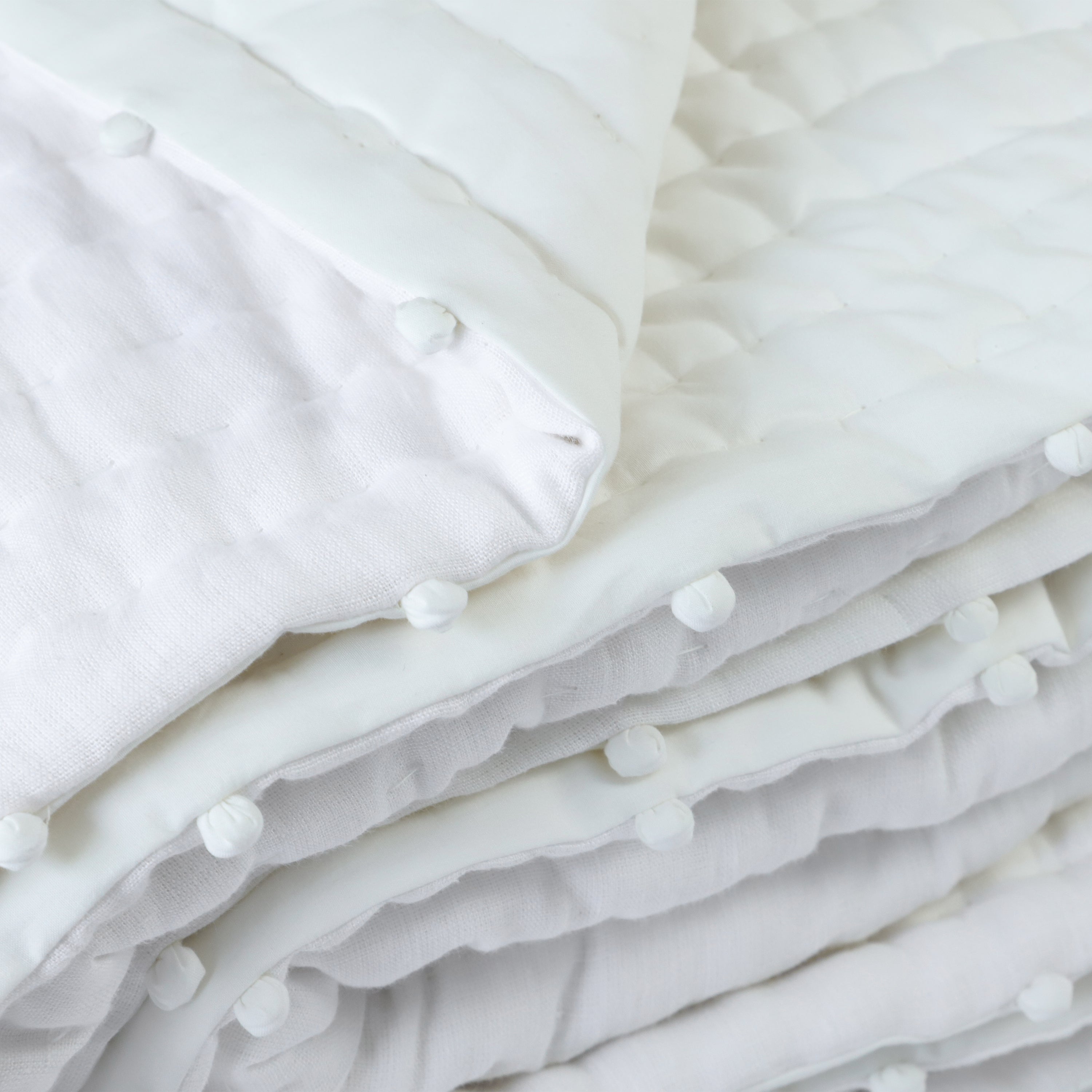 The pompom linen quilt is available in multiple sizes and shams can be purchased separately.