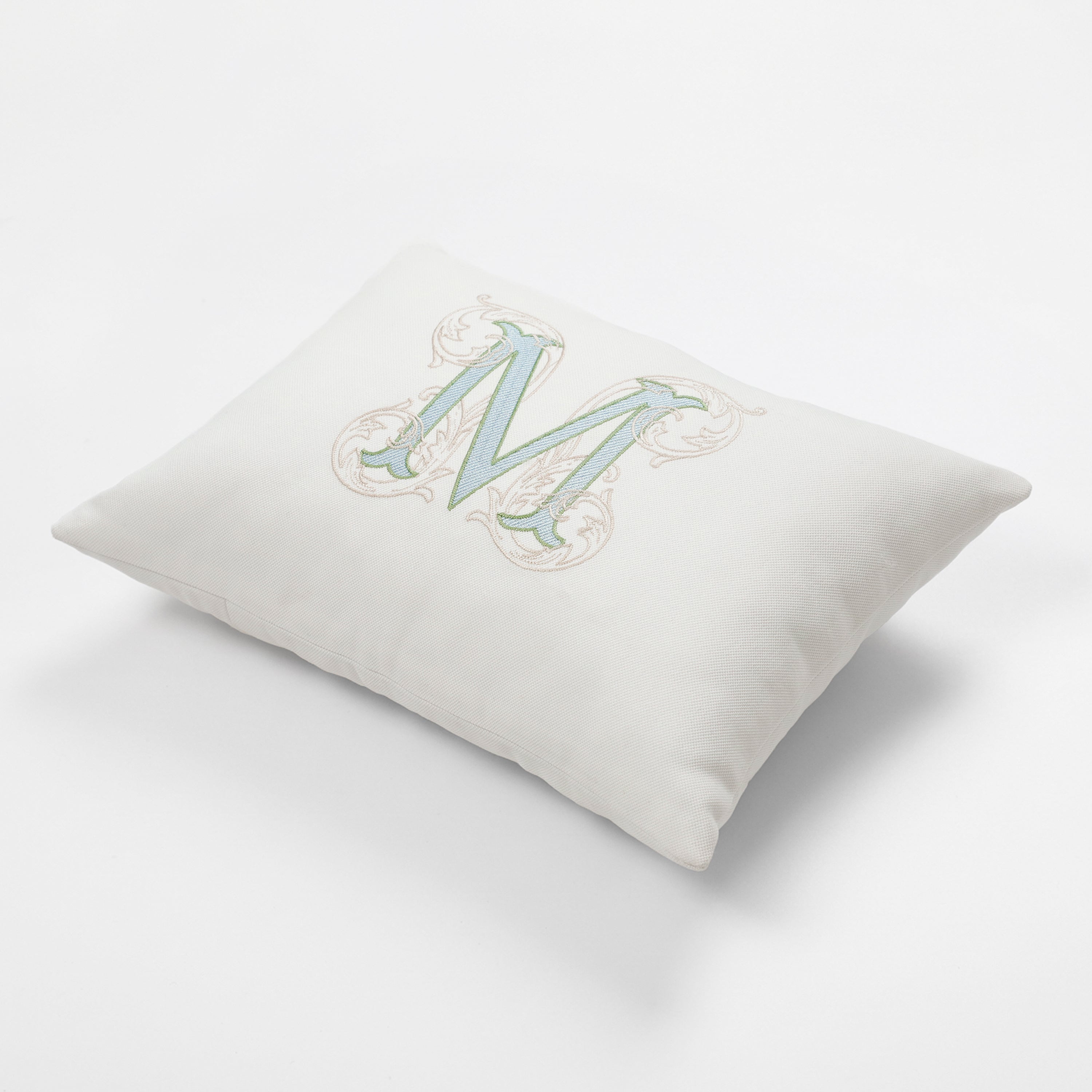 An isometric, angled view of the square personalized monogram pillow cover, highlighting its full shape and the precision of the detailed floral embroidery. The rich, structured texture of the ivory cotton canvas is evident, making this vintage-inspired cushion a standout addition to cozy reading nooks or farmhouse interiors. Fully lined for added strength, this durable custom initial pillow reflects an elegant, understated luxury style ideal for premium gifting.