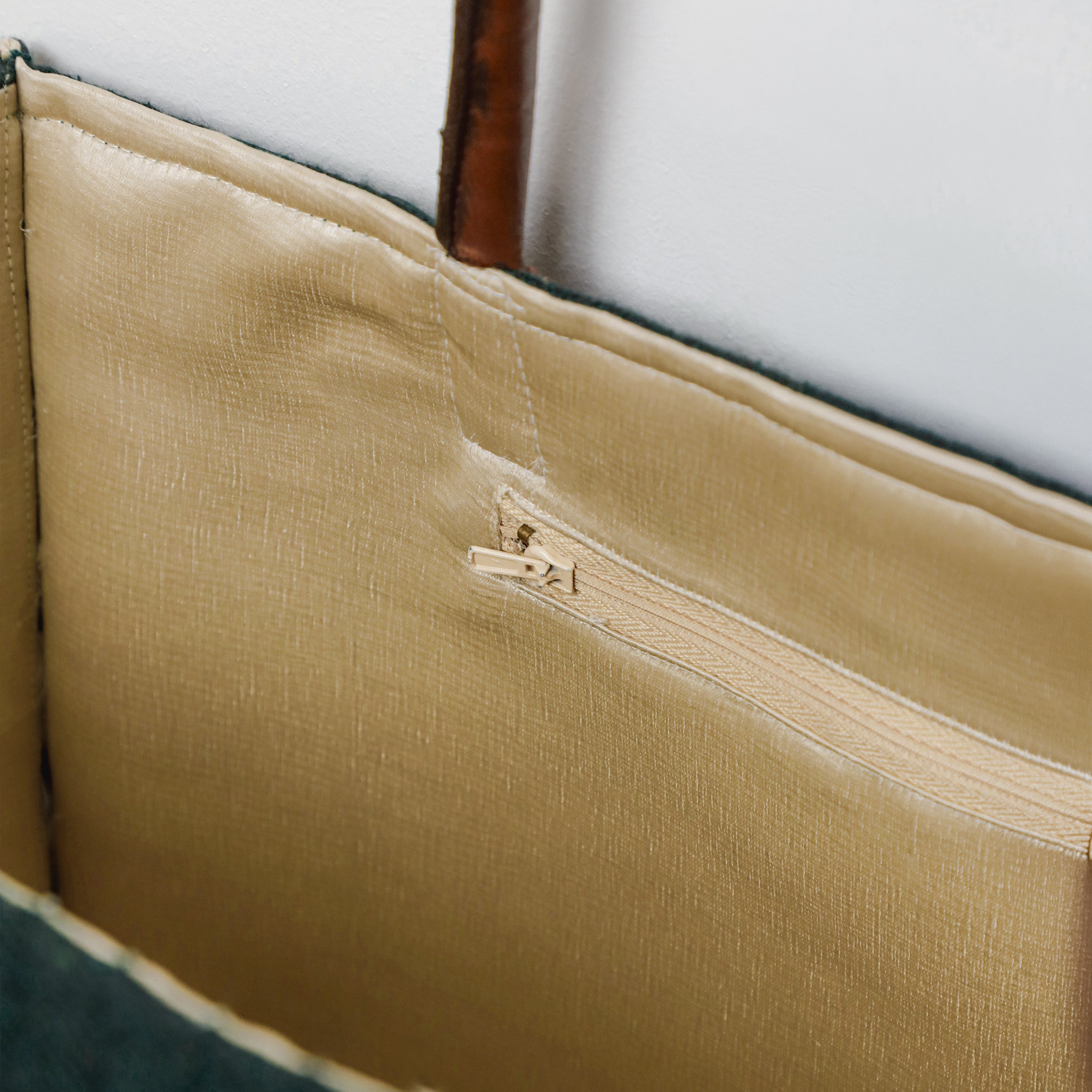Interior view of the Amore Beauté chevron tote bag featuring a soft golden fabric lining and a secure built-in zipper pocket for organized storage. This detail highlights the artisan craftsmanship and spacious design, perfect for keeping essentials like phones, keys, and wallets safe. A functional and elegant choice for women who value organized handbags and unique handmade purses for work or travel.