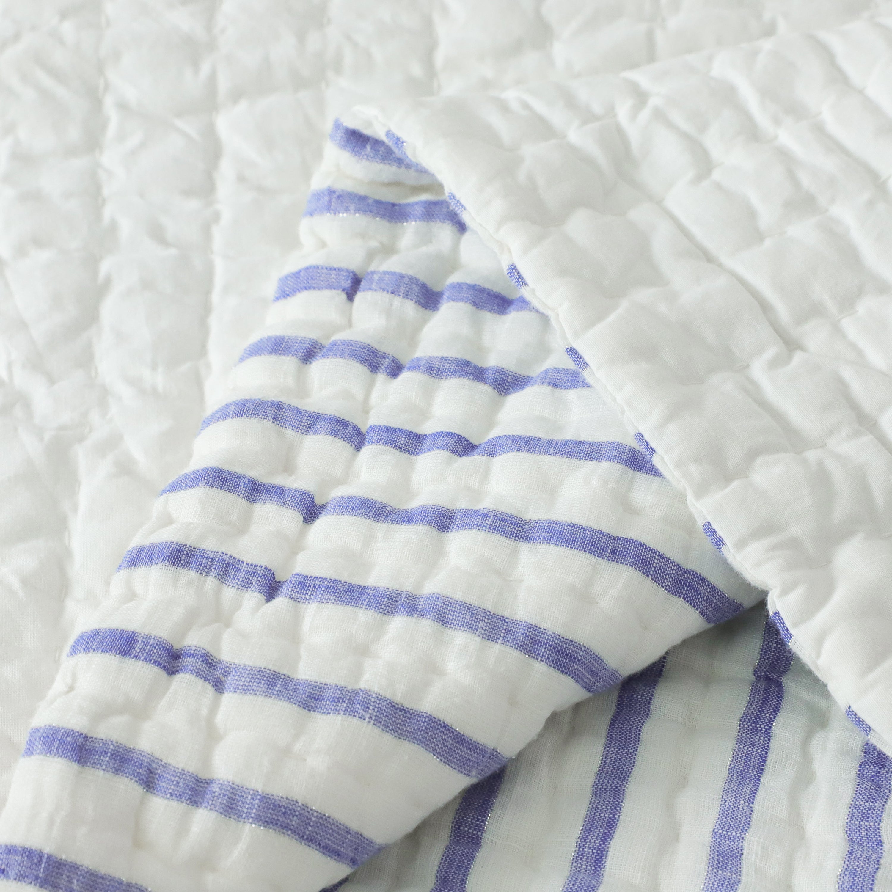 Handmade quilt reverses to solid cotton batting. The quilt is reversible and creates a cool summer vibe.