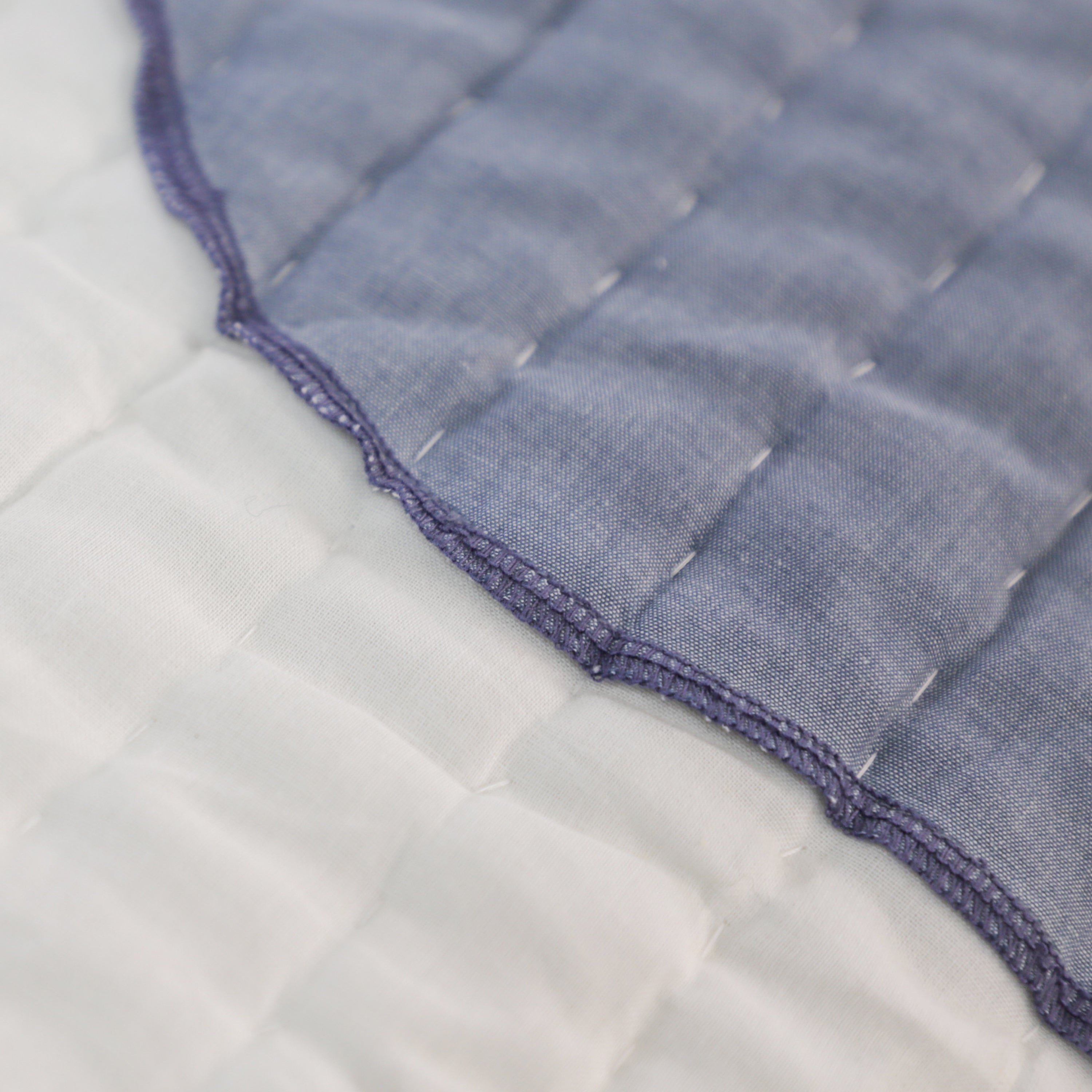 This reversible quilt features a patterned front and plain white cotton back, offering versatile use on both sides.