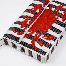High-angle flat lay view of the striped Handmade Beaded Crab Clutch with a large red crab motif.