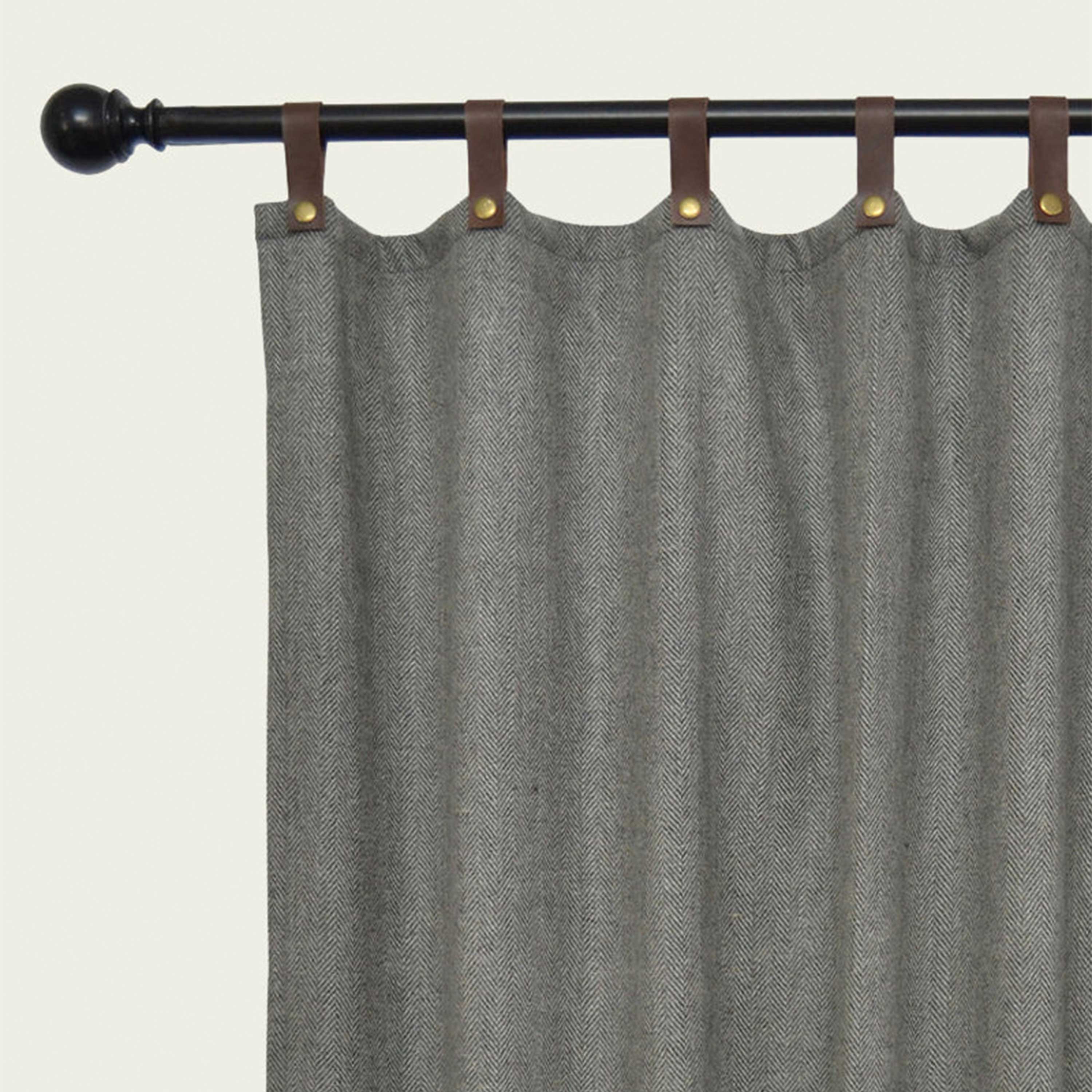 Custom-made window and door curtains crafted from herringbone wool and accented with leather tabs and snap buttons. 