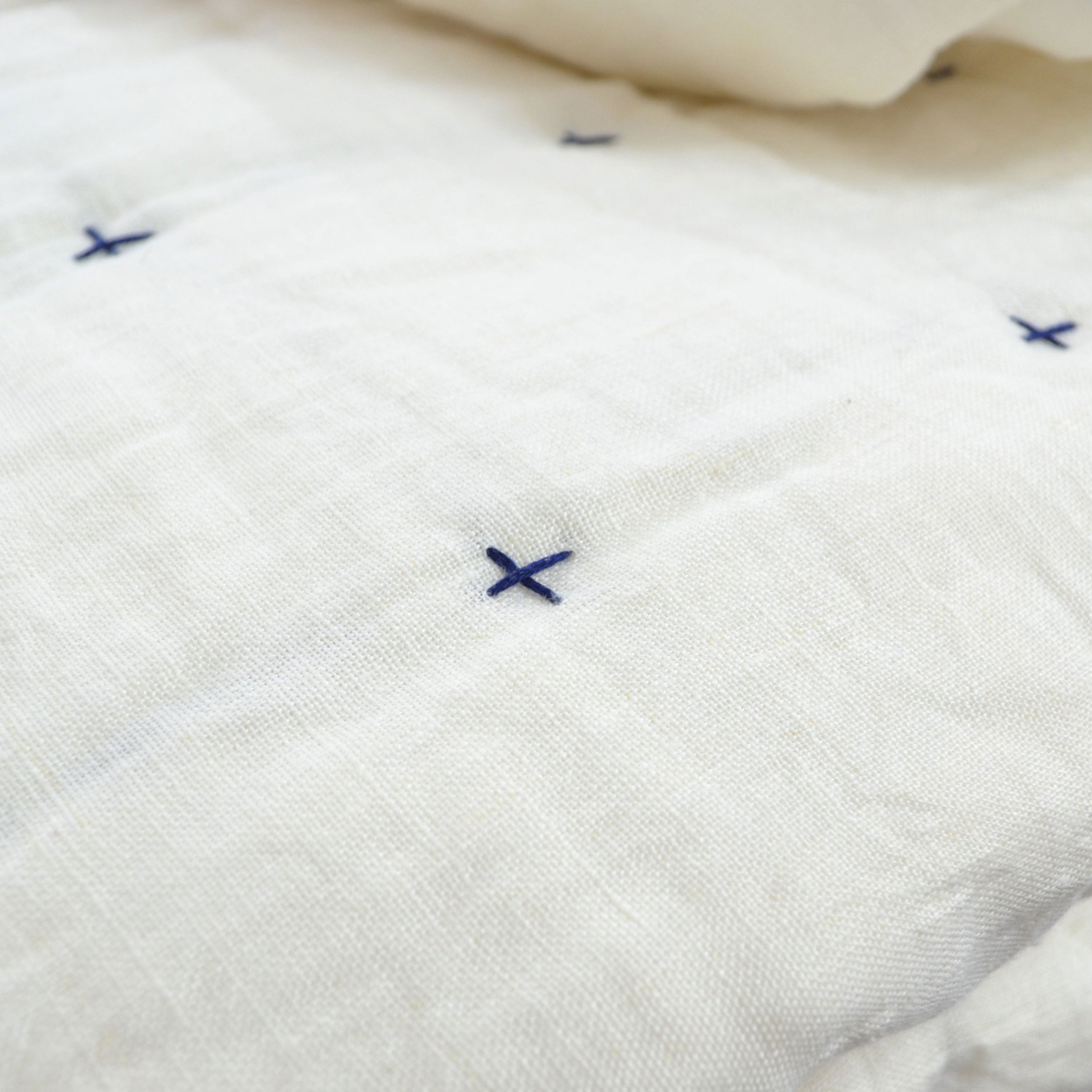 This quilt is made to order, featuring a linen top side, cotton reverse, and filled with soft cotton batting. It is machine washable on a gentle cycle with mild detergent for easy care.