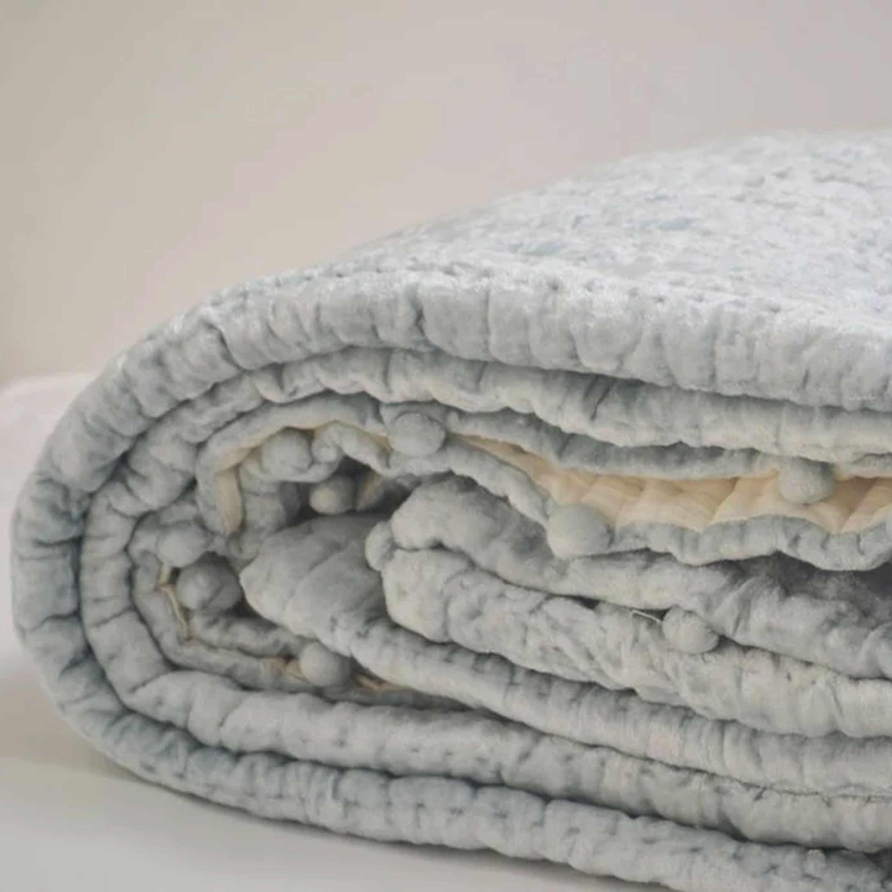 Pick-stitched for added texture, this soft plush icy blue velvet quilt is a popular color choice. It reverses to equally soft off-white cotton fabric for a cozy and elegant finish.