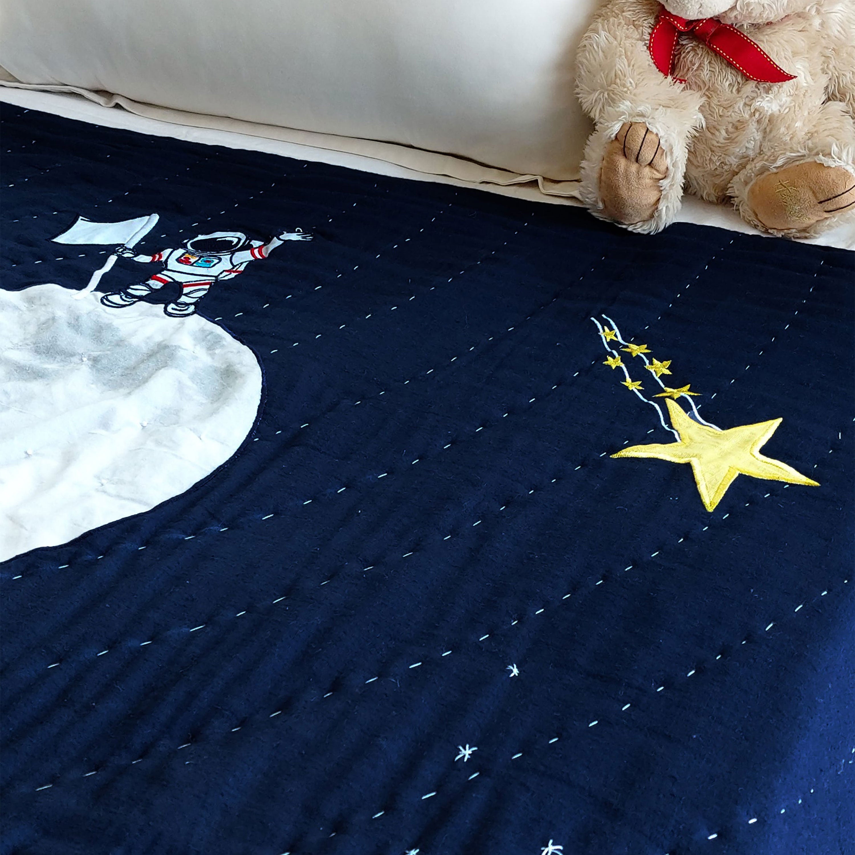 Traditional handcrafted quilt features cheerful planets, stars, and an astronaut landing, adding inspirational charm. Made from cotton front and reverse with 100% cotton batting, it ensures extra comfort for a restful sleep.