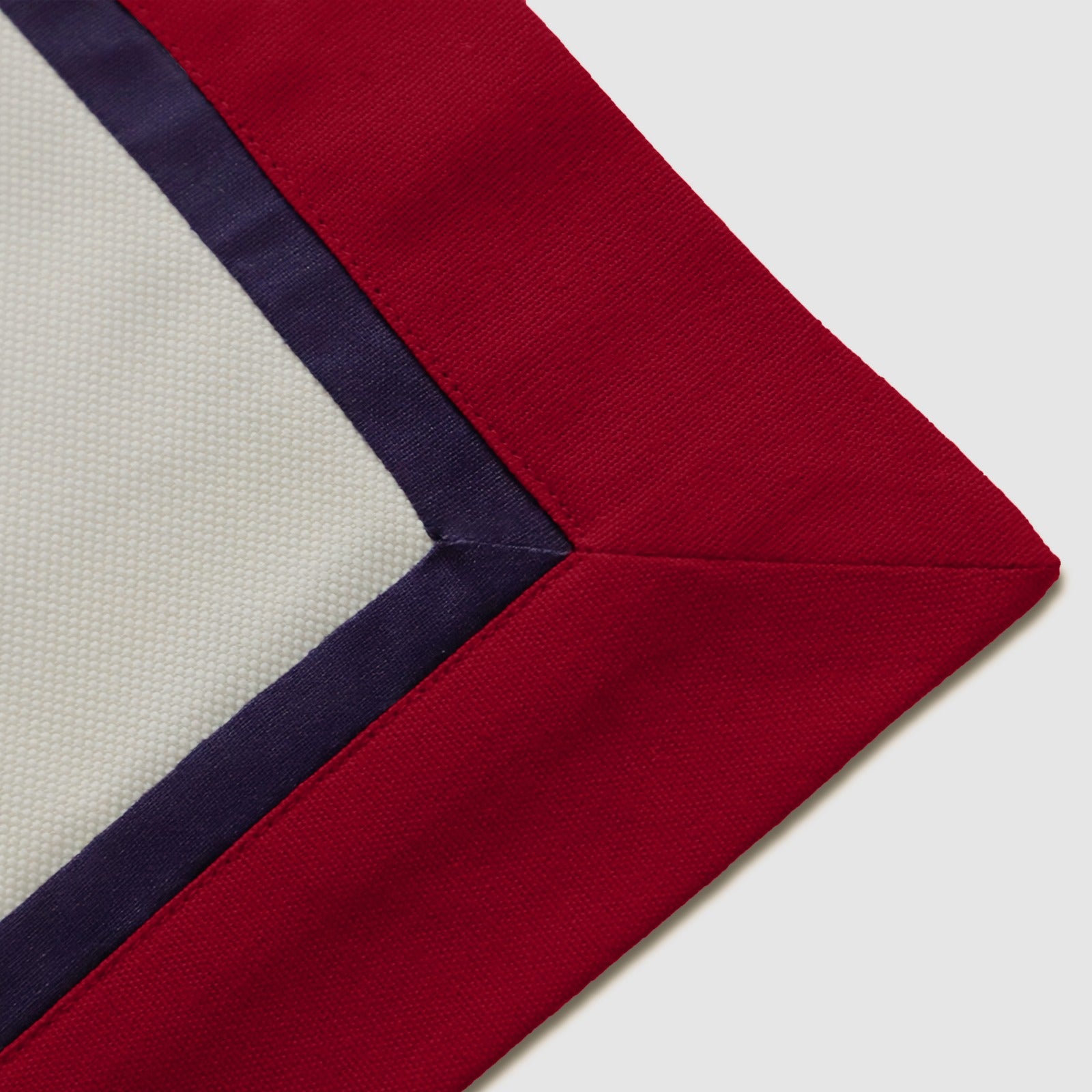 Macro close-up of the mitered corner stitching on the Ivory Table Runner With Custom Border.