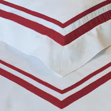 400 Thread Count Satin Cotton Duvet Cover Set with red Trim. The crisp white fabric features a smooth finish with two bold, parallel red borders stitched cleanly across the corner edges of the duvet and matching pillowcase.