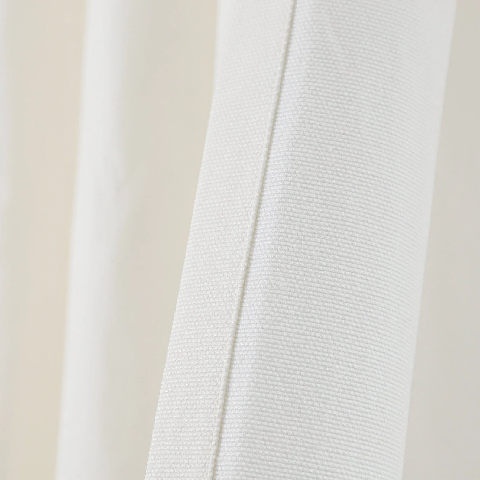 Close-up of a luxury ivory cotton blend drill fabric for a custom shower curtain, highlighting the durable canvas weave and impeccable stitching. This high-quality, quick-drying material from Amore Beauté is designed for high-end bathroom decor in luxury homes, spas, and boutique hotels. The neutral off-white tone and refined finish provide a minimalist modern vibe, ensuring long-lasting performance and a sophisticated feel for designers and premium buyers.