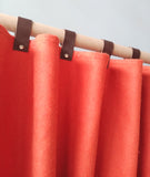 Amore Beaute orange wool felt curtains with leather snap tab.