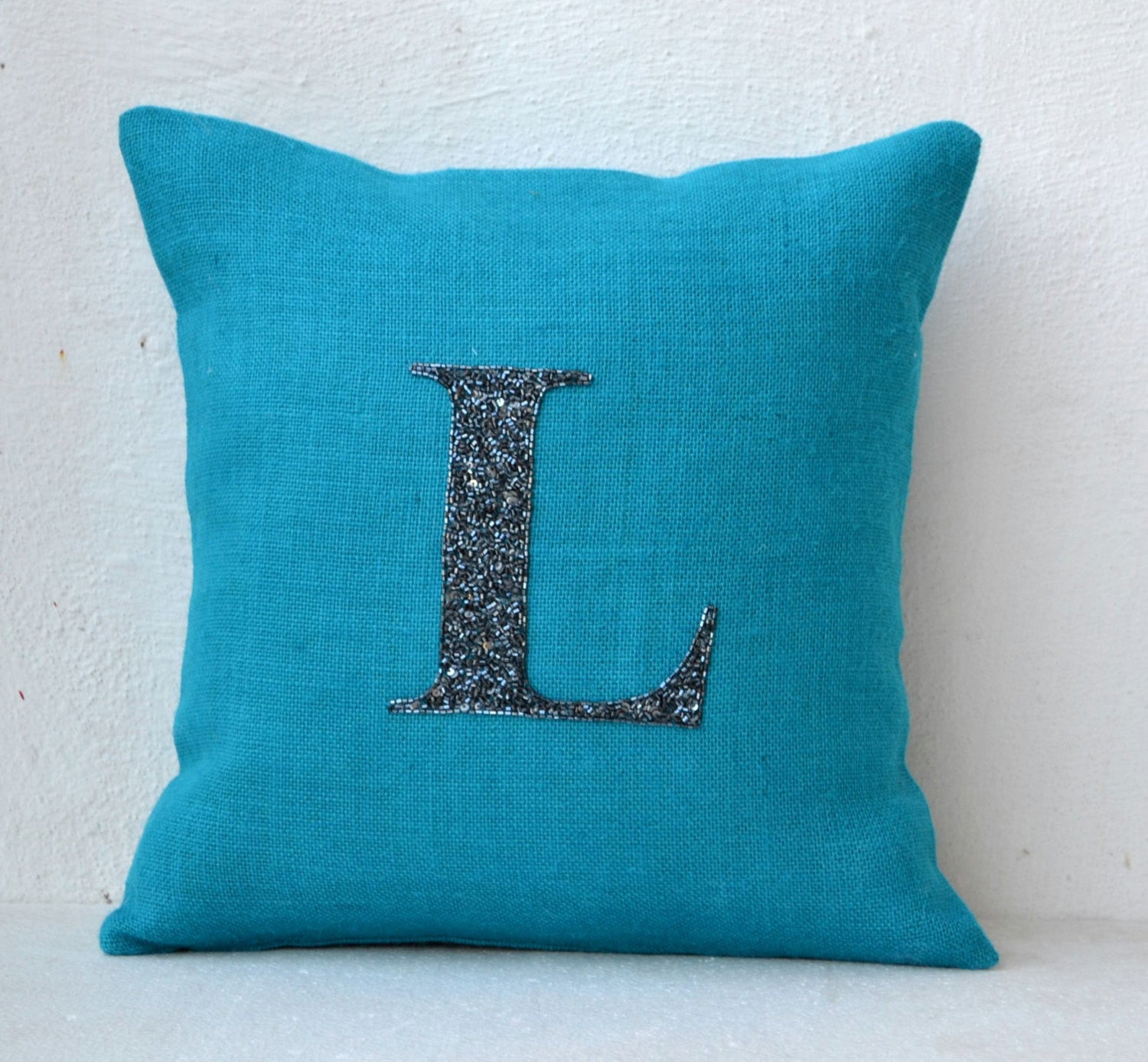 Amore Beaute Customized monogram in black beads and sequin on turquoise blue burlap.