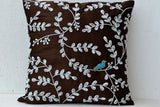 Amore Beaute design captures the beauty of a midsummer night with a turquoise bird on white beaded leaves intricately embellished on brown faux silk.